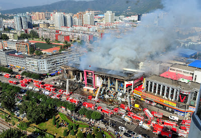 Smoke billowing from a shopping mall in the Shijingshan district in Beijing. Two firefighters died when they put out the fire that broke out in the early morning of October 11