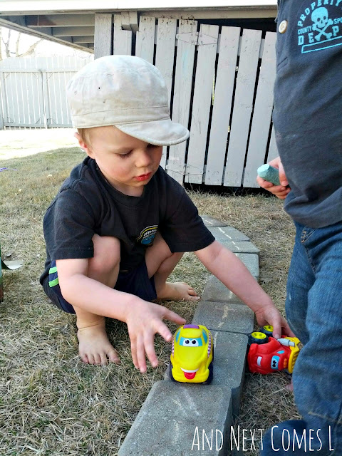 Child driving toy cars along DIY play roads
