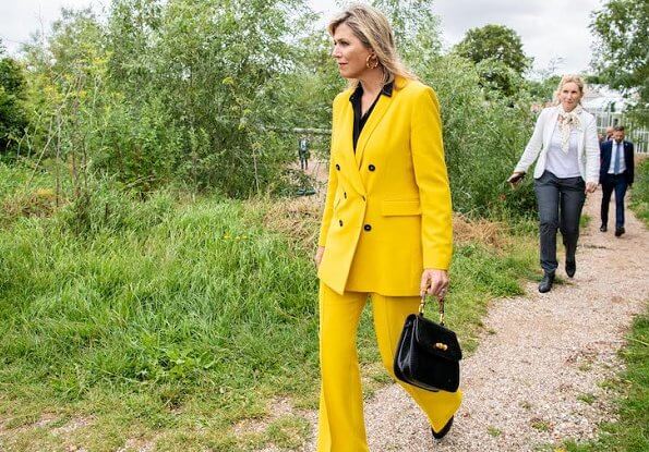 Queen Maxima wore a yellow blazer and trousers from Zara, Cartier gold bamboo earrings, carries Susan Gail bamboo handle handbag