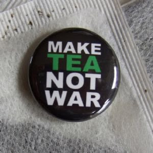 button reads make tea not war