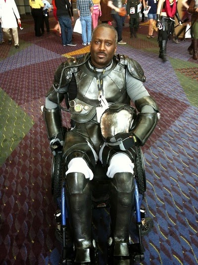 African-American man in full body armor sitting in a wheelchair