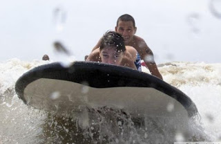 Imagen de un niño junto a un instructor en tabla de surf. Foto:Telám/ InfoGEI