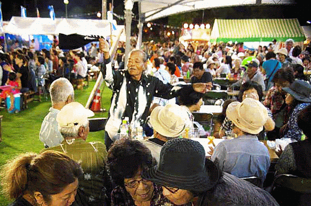 Festival crowd, clapping, dancing while listening to a live band