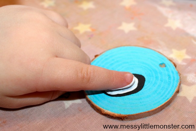 How to make fingerprint penguin wood slice Christmas ornaments. An easy kid - made Christmas ornament DIY for toddlers and preschoolers that doubles up as a keepsake.  Great for a penguin, snow or winter project.