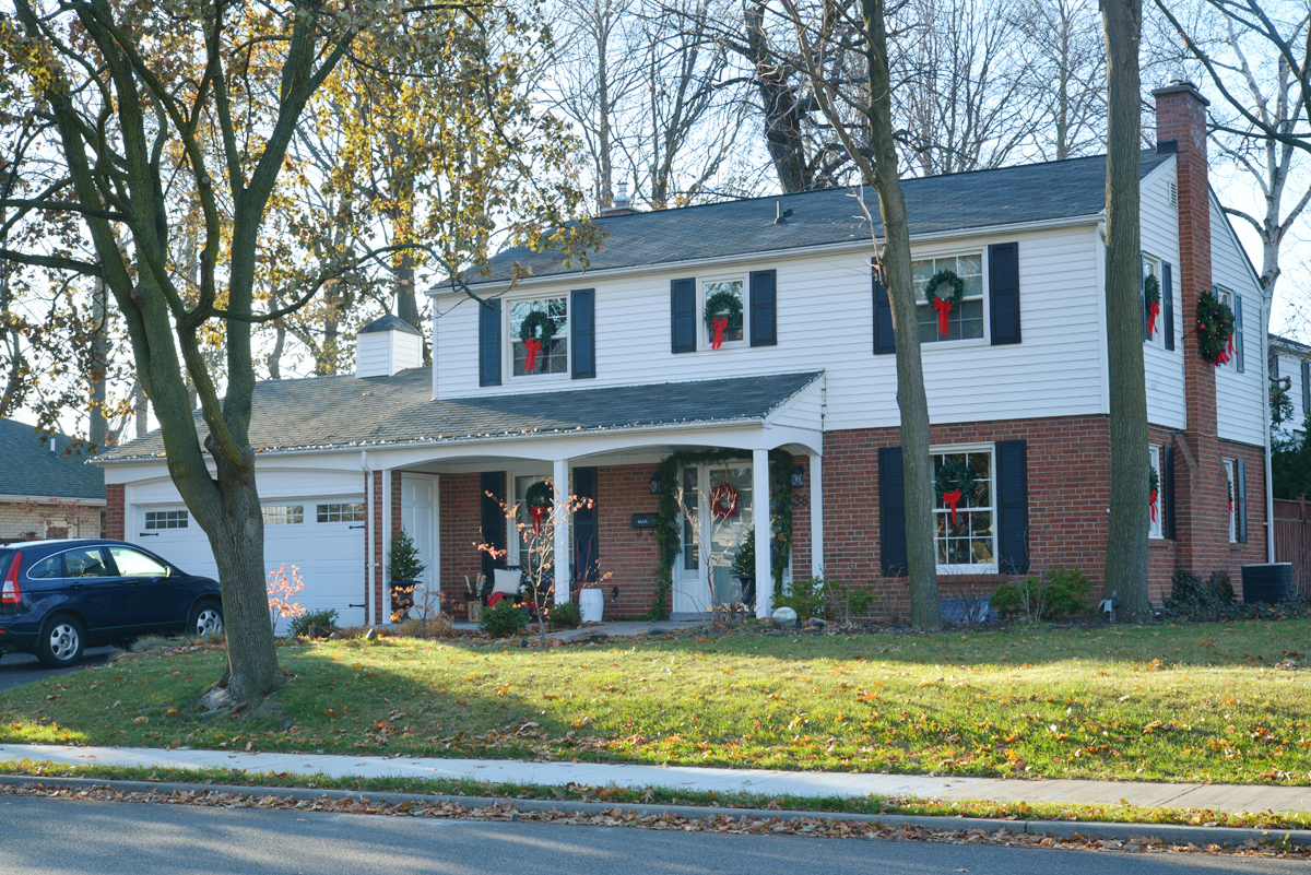 classic christmas decorations, colonial house with wreaths on windows, wreaths on exterior windows