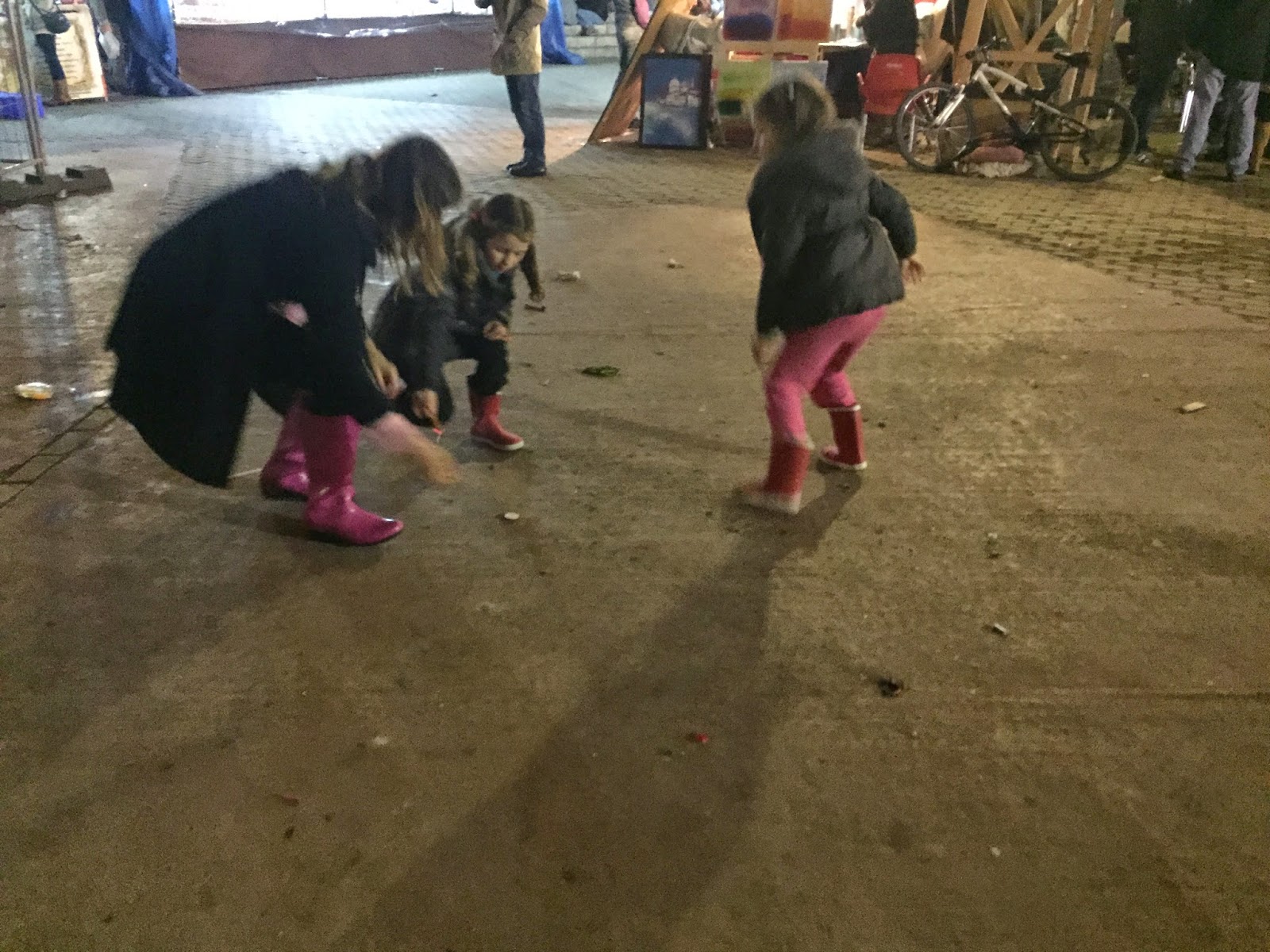 Little girls with their mom lighting petardos (fireworks) at darn near midnight