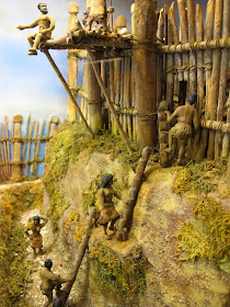 Diorama showing residents climbing up to Turuturu Mokai pa using a system of wooden logs with notches cut in them.