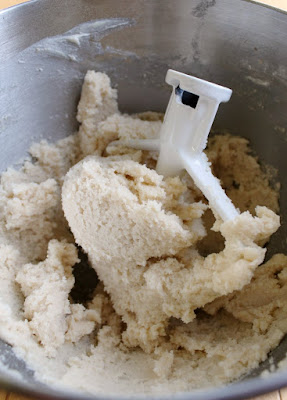 If you are a cookie dough lover, this is for you! It is basically safe to eat sugar cookie dough in frosting form and it's as good as it sounds! mixing bowl of sugar cookie dough frosting with paddle