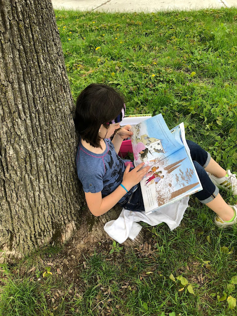 student reading against tree