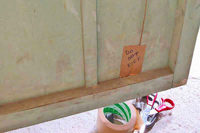outhouse door with cracks taped, Do Not Kick