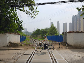 man riding a bike over a railroad track in Bengbu