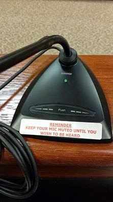 sticker added to microphones to make it more obvious that there is a mute button