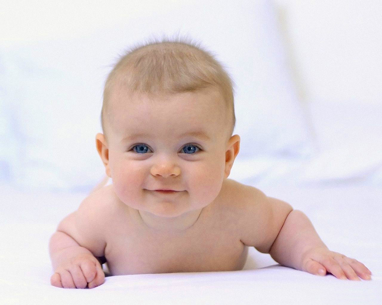 Baby wallpaper met baby op zijn buik die lacht