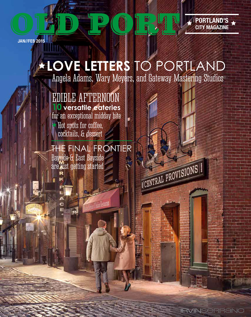 A young couple strolls down Wharf Street hand in hand in front of Portland, Maine's Jame's Beard award winning restaurant Central Provisions at dusk. 