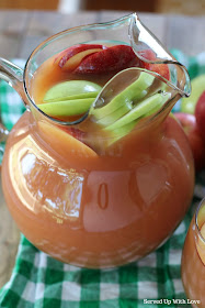 fall harvest punch with apples, pears, orange and cranberry in a glass pitcher