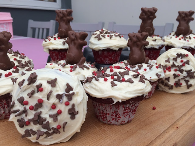 Red velvet cupcakes with reindeer and red nose sprinkles and chocolate reindeers perched inside