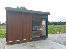 A honey shack along the side of the road.