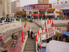 people removing Chinese and red flags at the Guomao Shopping Center in Mudanjiang