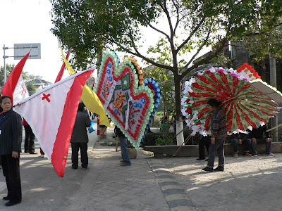 flags carried in funeral procession with a Christian cross
