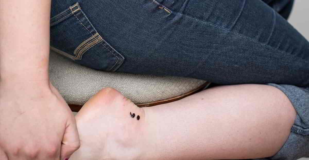 vemos a una chica con un tatuaje de punto y coma