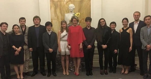 Queen Mathilde wearing a new red dress at a final of the Queen Elisabeth Music Competition. Crown Princess Elisabeth wore a white shoulder open embroidered dress