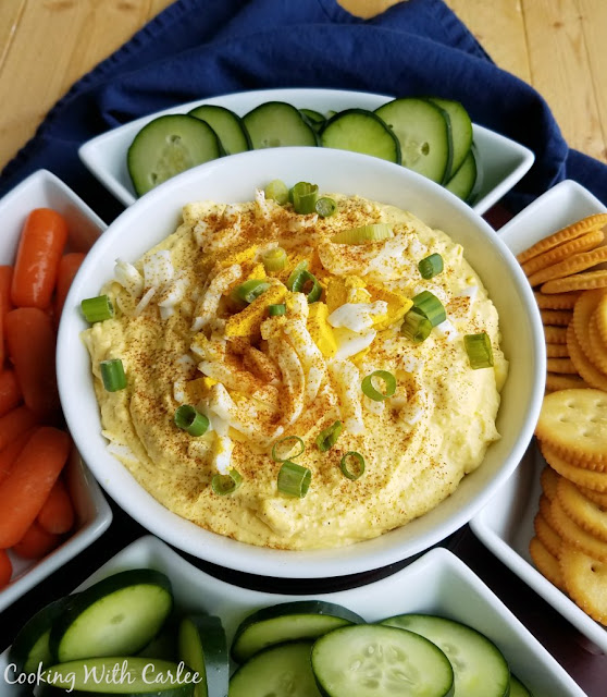 Do you love deviled eggs, but hate the pressure to make them perfect? Deviled egg dip gives you the flavor without worrying about peeling pretty eggs! bowl of deviled egg dip with carrots, cucumbers and crackers for dipping