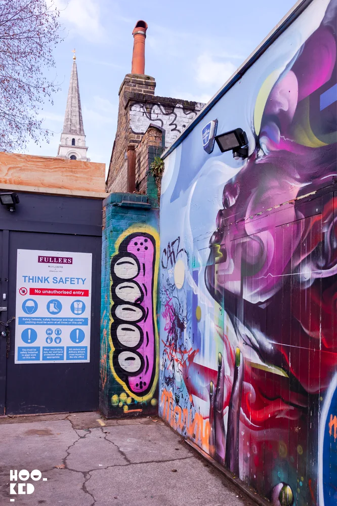 UK Street Artist Sweet Toofs' pink gummy teeth painted on a London wall