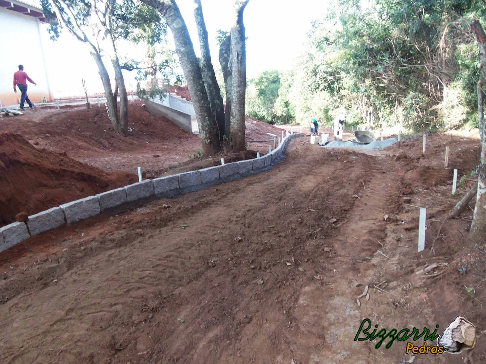 Iniciando o calçamento de pedra folheta com colocação das guias de pedra folheta.