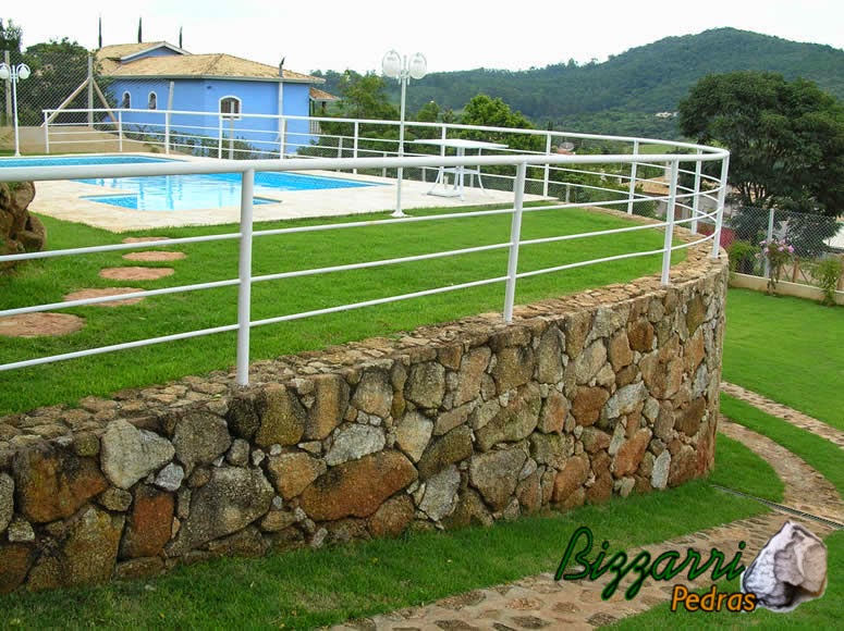 Calçamento de pedra rústica na entrada da residência com faixa de 70 cm de largura com a execução do muro de pedra rústica e construção da piscina com a construção da residência.