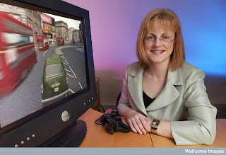 Eleanor Maguire with a video game that simulates driving a taxi through the streets of London