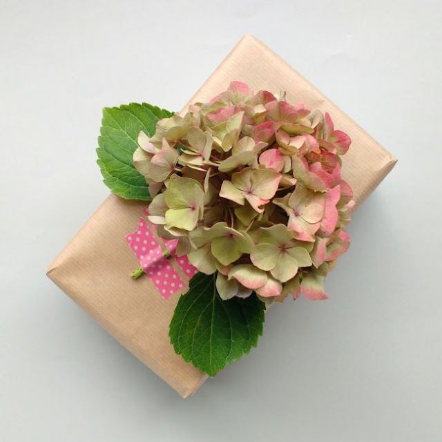 Get creative with your gift wrapping with these 10 DIY gift wrap ideas! brown paper parcel with a hydrangea bloom as a gift topper