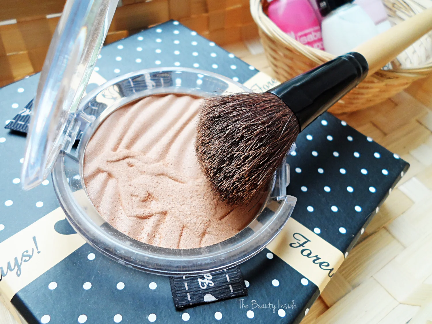 an opened bronzing powder by essence with a face brush