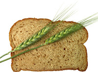 wheat spears laying across slice of whole wheat bread