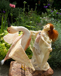 sculpture of bird and doll, both made from clay and fabric