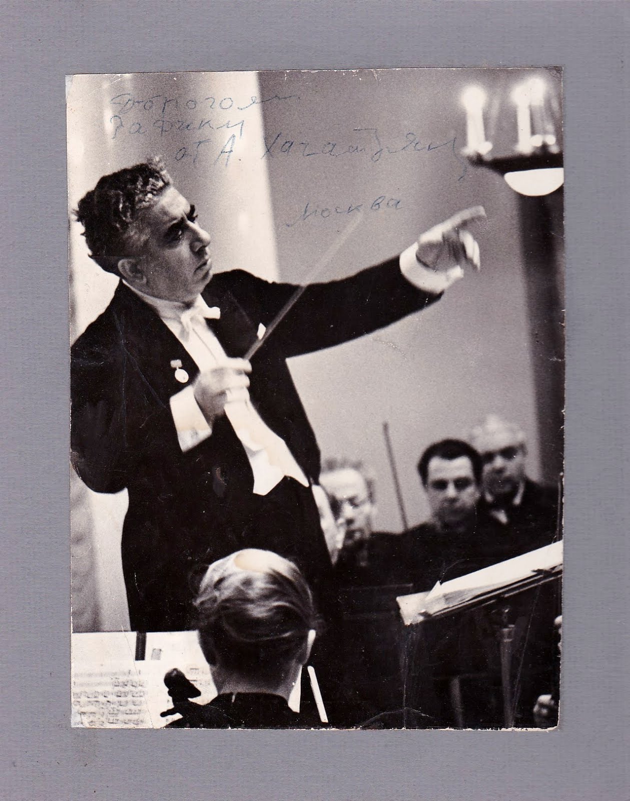 Composer Aram Khatchaturian autographs a photograph conducting the Leningrad Philharmonic