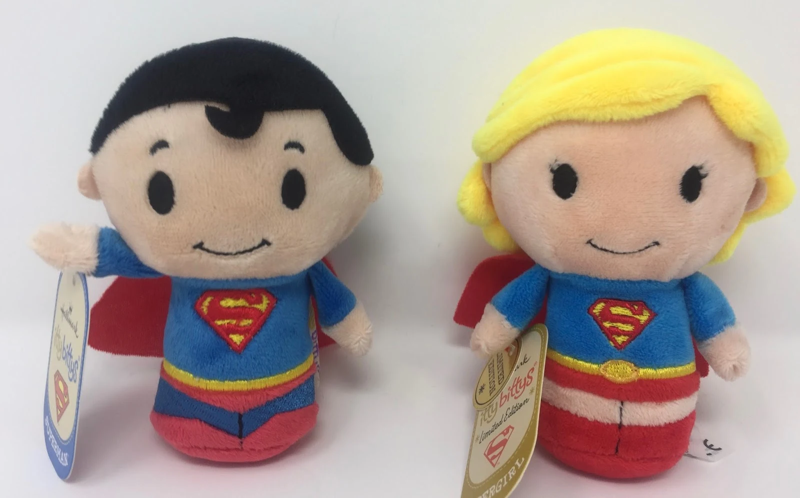 Small plush figures looking like super man and super girl