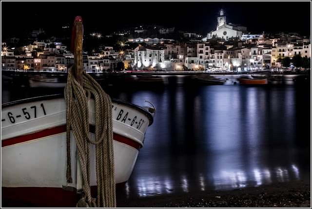 Cadaqués: Nocturna de la población con barca en primer plano