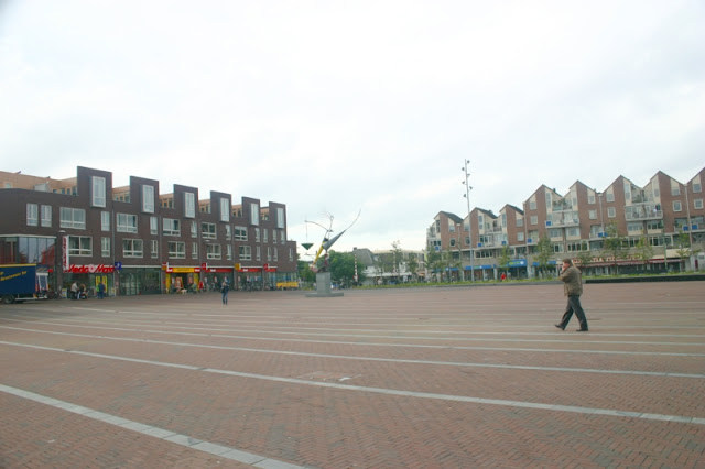 Ede center square lined with shops and modern apartments.