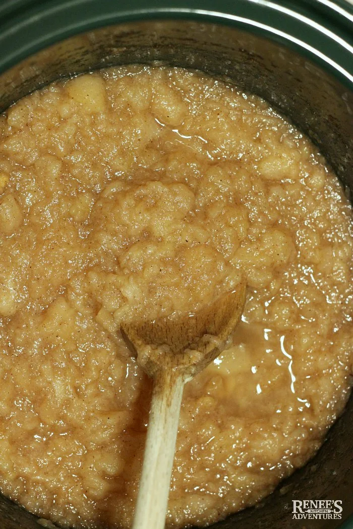 Slow cooker applesauce done in crockpot with wooden spoon