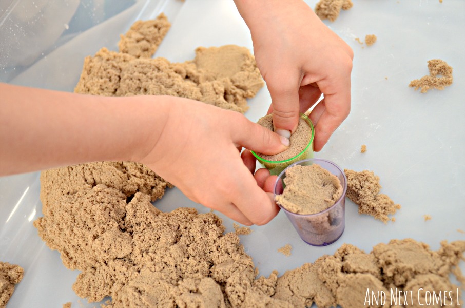 Fine motor sensory play activity with kinetic sand and colorful cups