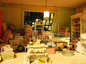 Third floor of a modern miniature shabby chic shop, with a display of soft furnishings and furniture.