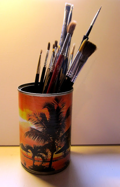 Recycling tin cans as pencil holders by decoupaging magazine pictures on them. 
