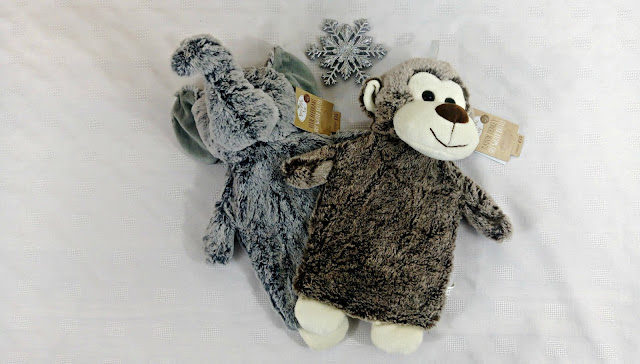 Two furry hot water bottles in the shape of a monkey and an elephant