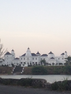 Photo of a white castle by a river. 