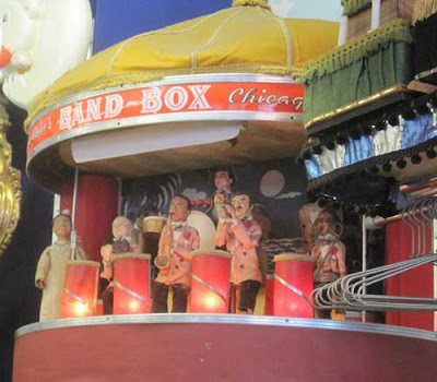 Bandbox structure with dolls inside it with instruments