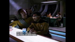 Worf bends in towards LaForge at the bar of Ten Forward, saying "You must let her see the fire in your eyes."