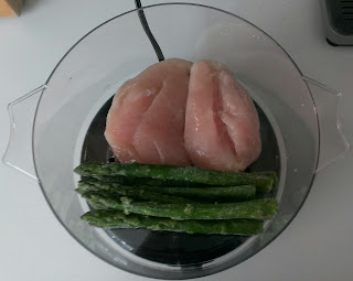 chicken breasts and asparagus spears in a steamer