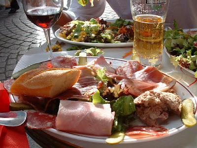 plate of meats and bread, glass of wine and beer