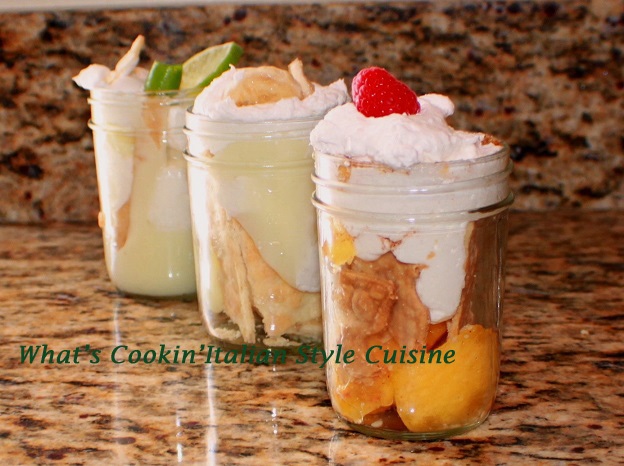 these are mason jars filled with pie crust broken up and how to make mason jar pies. The jars are filled with key lime pudding, banana cream pudding and strawberries, cream and pudding. All no bake pies in a glass mason jar.