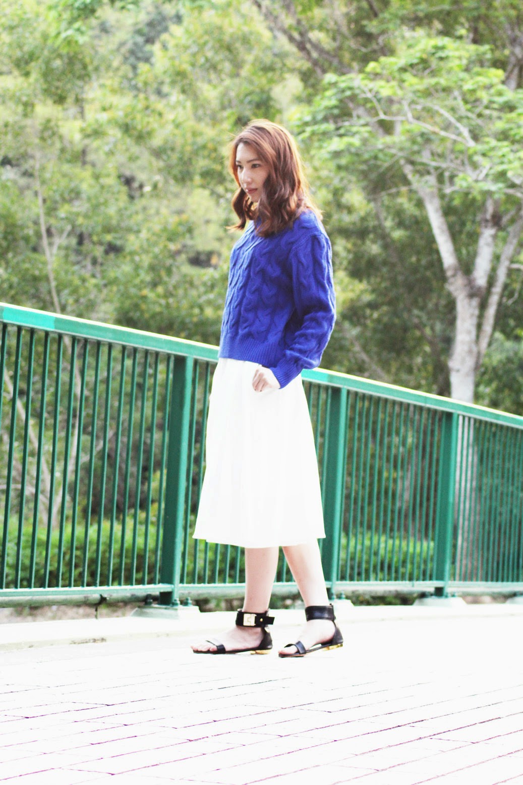 Styling blue sweater with flared white midi skirt and gold buckled sandals